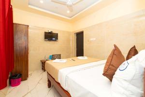 a bedroom with a bed and a tv on the wall at Hotel Amman Residency in Rāmeswaram