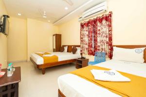 Cette chambre comprend 2 lits et une fenêtre. dans l'établissement Hotel Amman Residency, à Rameswaram