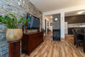 a living room with a tv and a brick wall at Villa I&M in Jasenice
