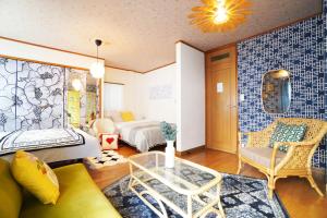 Habitación con cama, sofá y mesa. en MATATABI STAY Alita Motomachi 3F, en Osaka