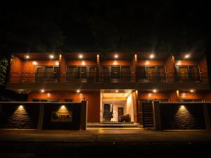 uma casa com varanda à noite com luzes em Yogu's Woodside em Sabari