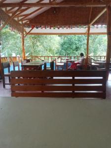 a wooden bench in a pavilion with a person sitting at a table at Orchid Bugalows. in Timbanglawang
