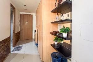 Zimmer mit Holzwänden und einem Flur mit Topfpflanzen in der Unterkunft RedLiving Apartemen Treepark City - Nuansa Property Tower Alpine in Kebonnanas