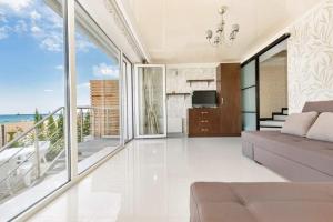 a living room with a couch and a balcony at Сучасна вілла у моря in Odesa