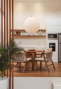 a kitchen with a table and chairs and a dining room at Villa Alya Seaside by Pura Homes in Canggu
