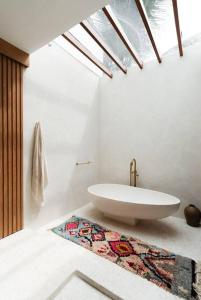 a bathroom with a sink and a rug on the floor at Villa Alya Seaside by Pura Homes in Canggu