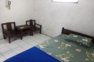 een slaapkamer met een bed en een tafel en stoelen bij Kalingga Sekar in Yogyakarta
