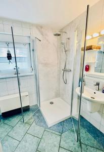 ein Bad mit einer Dusche und einem Waschbecken in der Unterkunft Ferienhäuschen im Grünen in Weimar