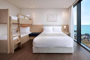Postel nebo postele na pokoji v ubytování Shilla Stay Plus Iho Tewoo Ocean Front