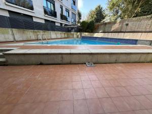 - une piscine au milieu d'un bâtiment dans l'établissement Holibai, Parruliña, Estudio Con Terraza, Piscina, Parking Wifi, à Baiona