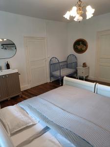 1 dormitorio con 1 cama blanca y 2 sillas en Moulin de Bellicout, en Charmé
