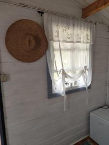 a window in a room with a white curtain at Metsatuule puhkeküla in Hiiumaa
