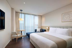 Postel nebo postele na pokoji v ubytování Shilla Stay Plus Iho Tewoo Ocean Front