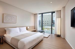 Postel nebo postele na pokoji v ubytování Shilla Stay Plus Iho Tewoo Ocean Front