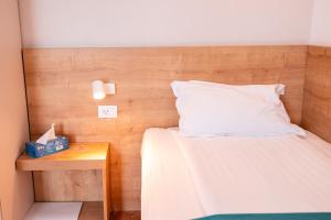 uma cama com uma cabeceira de madeira ao lado de uma mesa em Stil Hotel em Bucareste