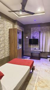 Schlafzimmer mit einem Bett und einem Flachbild-TV in der Unterkunft Supreme Hotels 2.0 in Warangal