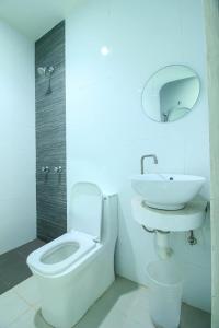 a bathroom with a white toilet and a sink at Astrotel Avenida in Manila