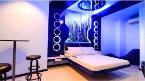 a bedroom with a bed and two stools in it at Astrotel Avenida in Manila