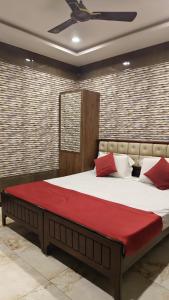 una camera da letto con un grande letto con una coperta rossa di Supreme Hotels 2.0 a Warangal
