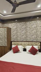 een slaapkamer met een groot bed met 2 rode kussens bij Supreme Hotels 2.0 in Warangal