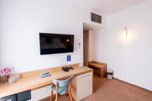 a room with a desk and a tv on a wall at Stil Hotel in Bucharest