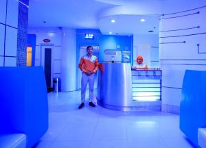 a man standing in a room with a refrigerator at Astrotel Avenida in Manila