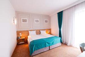 布加勒斯特Stil Hotel的一间卧室，配有一张大床和一扇窗户。