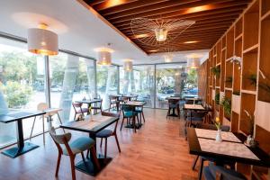 un ristorante con tavoli, sedie e finestre di Stil Hotel a Bucarest