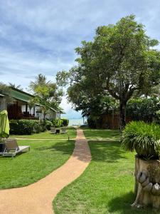 a walkway through a lawn with a tree and a house at The Joy Beach Villas in Hinkong