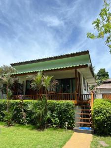 uma pequena casa com um alpendre e escadas para ela em The Joy Beach Villas em Hinkong