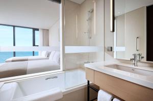 Postel nebo postele na pokoji v ubytování Shilla Stay Plus Iho Tewoo Ocean Front