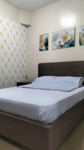 Ce lit se trouve dans une chambre ornée de 3 peintures murales. dans l'établissement Iloilo Condominiums, à Iloilo