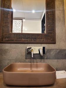 a sink in a bathroom with a mirror at Riverarch Greenfields Resort in Chandwaji