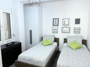 een slaapkamer met 2 bedden en een zwarte dressoir bij Apartment Olive in Dhërmi