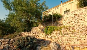 a stone wall with trees and a building at Villa Kounouvato in Perakhórion