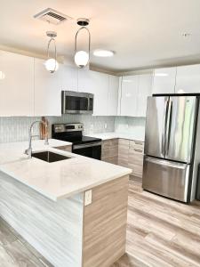 a kitchen with white cabinets and a stainless steel refrigerator at Luxury 2 Bed Apartment in Quincy in Quincy