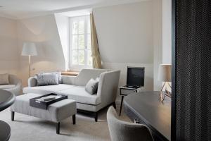a living room with a white couch and a tv at Hotel Landhaus Wachtelhof in Rotenburg an der Wümme