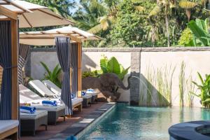 an elephant standing next to a pool at a resort at The Compass Rose Ubud in Ubud