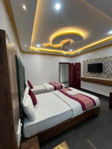 1 dormitorio con 2 camas y TV en el techo en HOTEL COUNTRY INN, en Dimāpur