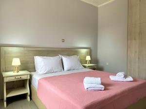a bedroom with a pink bed with towels on it at Armonia Apartment Spartia in Spartia