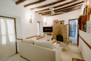 a living room with a white couch and a fireplace at Retreat Kritou Tera House No1 Casa de Familia in Paphos City
