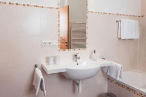 ein weißes Badezimmer mit einem Waschbecken und einem Spiegel in der Unterkunft Huberhof in Natz-Schabs