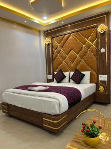 sypialnia z dużym łóżkiem z drewnianym zagłówkiem w obiekcie HOTEL COUNTRY INN w Dimapur