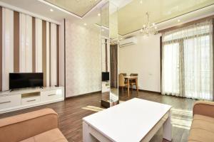 a living room with a television and a table at Luxe Apartment in the Center of Yerevan 007 in Yerevan