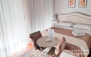 um pequeno quarto com uma cama e uma mesa em B&B Greco Home em Taormina