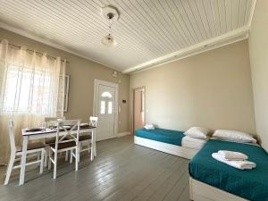 a room with two beds and a table and a dining room at Armonia Apartment Spartia in Spartia