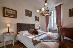 a teddy bear sitting on a bed in a bedroom at La Casa Consuelo ~ Piscine ~ Jardin ~ Centre ville in Carcassonne