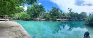una piscina di acqua blu con alberi sullo sfondo di Le Better Inn Hotel a Port Vila