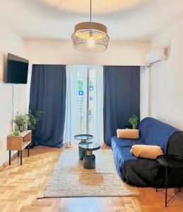 een woonkamer met een blauwe bank en blauwe gordijnen bij Chez Ethan, 5 min à pied de l'Acropole in Athene