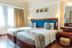 Pokój hotelowy z 2 łóżkami i lustrem w obiekcie Royal Hotel Saigon w Ho Chi Minh